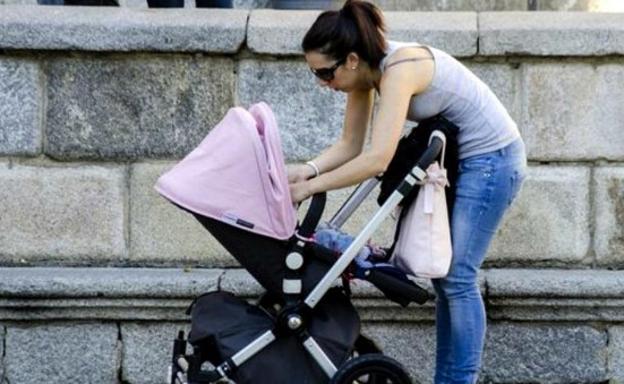 Una mujer con su hijo en el carrito.