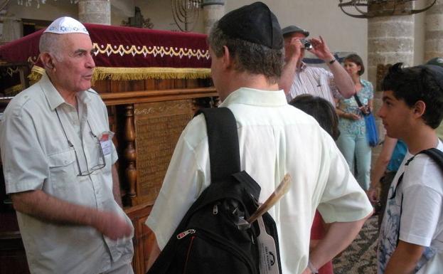Turistas hablan con un judío sefardí superviviente del Holocausto.