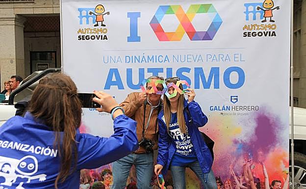 Una pareja se hace una fotografía con el símbolo multicolor del infinitio en el panel de la avenida del Acueducto. 