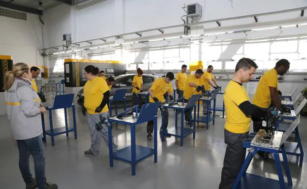 Los alumnos del taller de automoción Efidies trabajan para ganar destreza con la pistola neumática. 