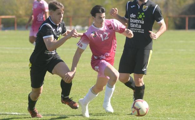 El jugador del Universitario conduce el balón entre dos rivales del Toralense. 