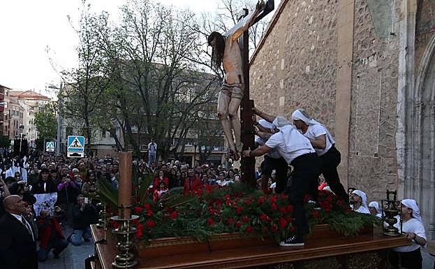 Tres costaleros colocan el Cristo en posición vertical. .