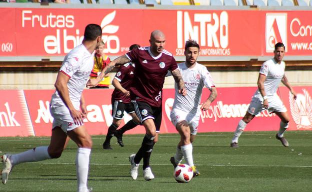 Chatón conduce el balón ante dos rivales de la Cultural. 