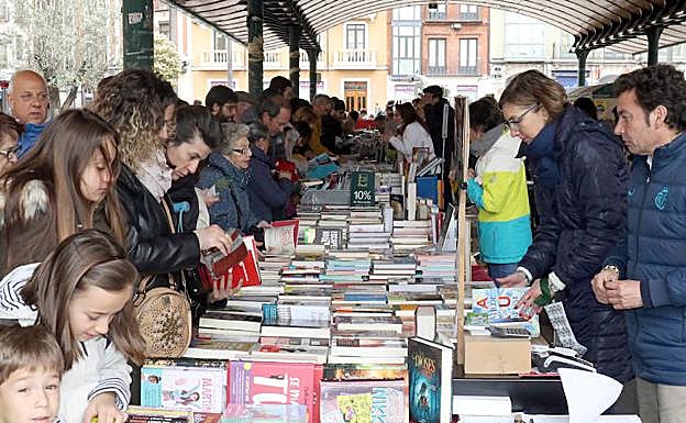 Público infantil y adulto busca libros en la Plaza de España. 