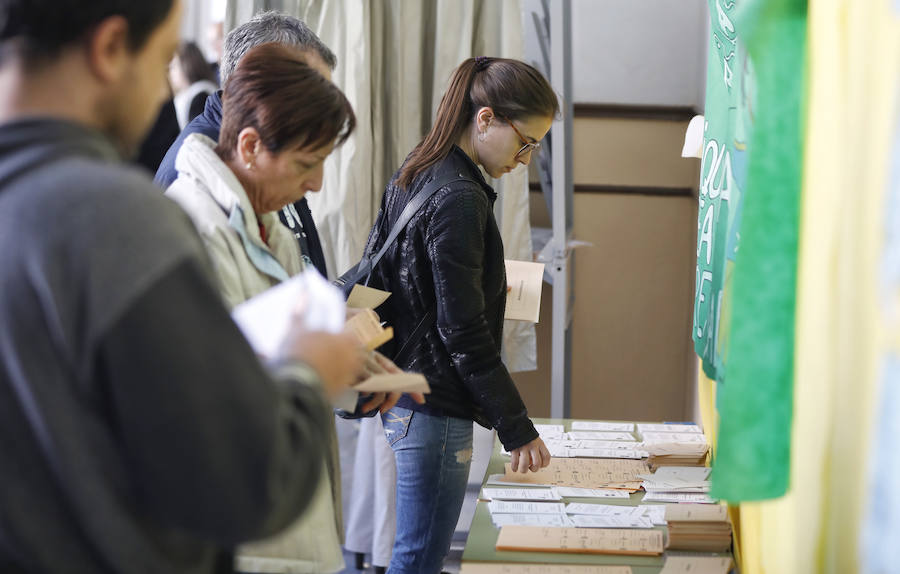 Una joven selcciona su papeleta en un colegio electoral de Valladolid