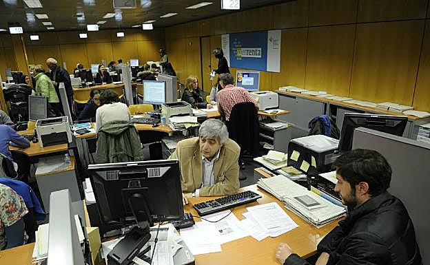 Funcionarios de la Agencia Tributaria atienden a varios ciudadanos en una de sus oficinas.