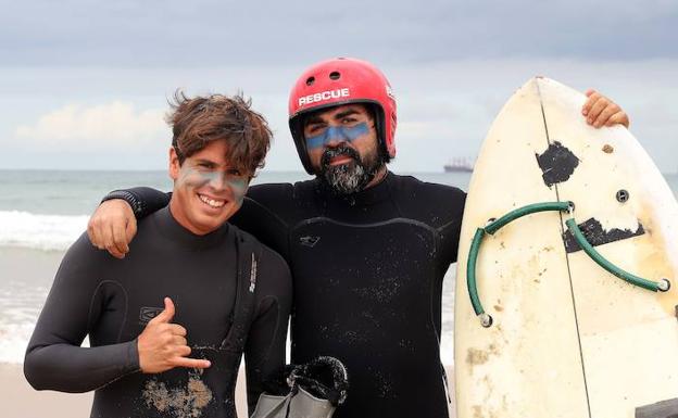 Ángel Luis Curiel, 'Curi', a la derecha, junto a su 'caddie' Miguel antes de entrar al agua en Somo.