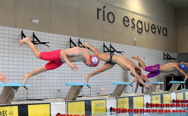 Los nadadores se lanzan a la piscina. 