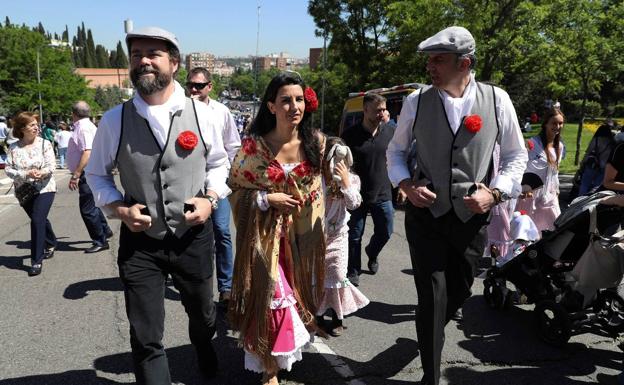 La candidata de Vox a la Comunidad de Madrid, Rocio Monasterio acompañada de su esposo, Iván Espinosa de los Monterios (i) y el candidato de Vox a la alcaldía de Madrid, Javier Ortega Smith,d., durante el recorrido que realizaron por la Pradera de San Isidro.