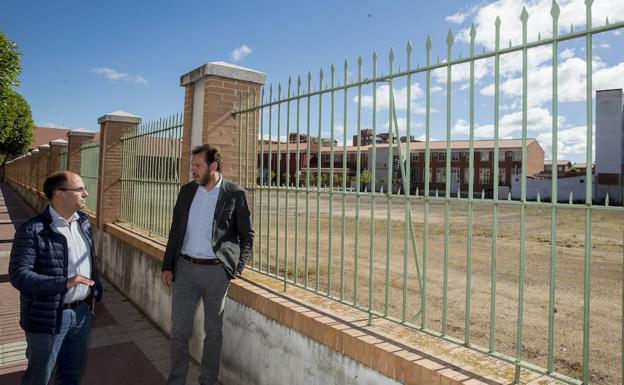 Luis Vélez y Óscar Puente, junto a la parcela del centro Juan de Herrera que quieren convertir en aparcamiento. 