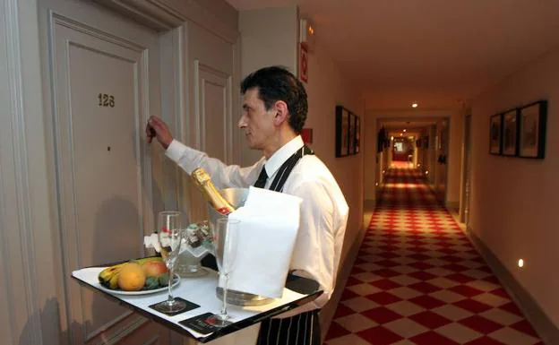 Un camarero de hotel lleva un pedido a una habitación.