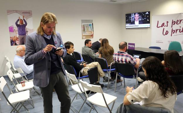 Pablo Fernández, tras conocer los resultados, consulta el móvil. En la primera fila, Miguel Holguín, candidato a la Alcaldía de Valladolid. 