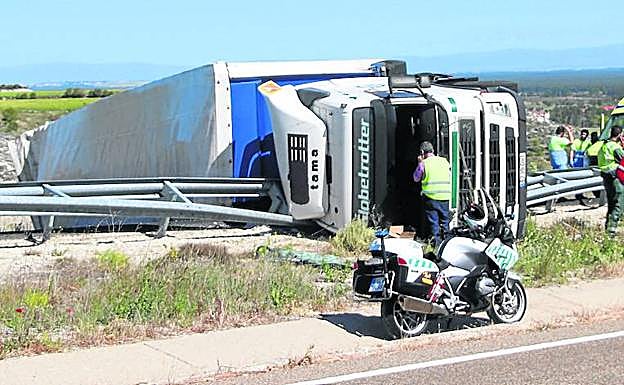 Vista del camión volcado en la autovía de Pinares en el accidente ocurrido cerca de la localidad de Cuéllar. 