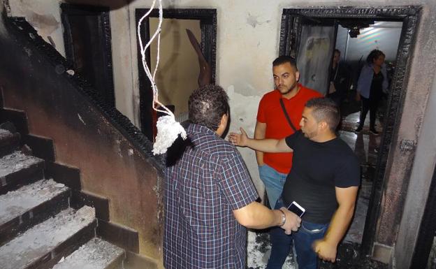 Los vecinos inspeccionan el rellano del piso en el que se han producido el incendio.