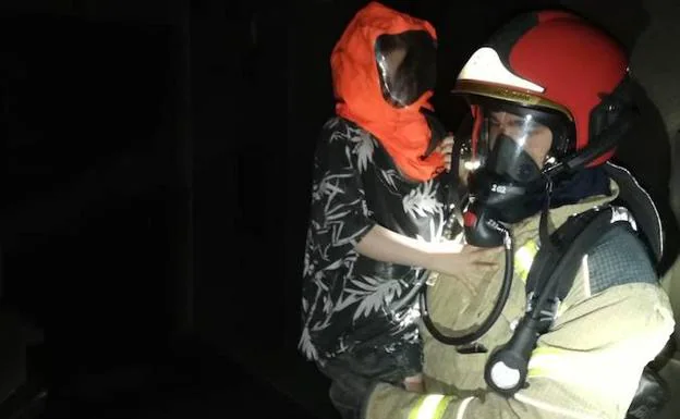 Un bombero traslada a uno de los menores fuera del inmueble. 