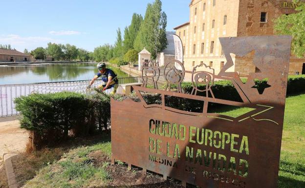 Un ciclista llega junto a escultura de la Ciudad Euroea de la Navidad.