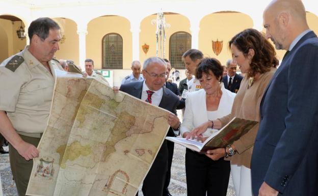 El general José Rivas, jefe de la IV Subispección del Ejército de Tierra, despliega uno de los mapas que tiene un libro, junto a la delegada del Gobierno en Castilla y León, Mercedes Martín, y el subsecretario del Ministerio de Defensa, Alejo de la Torre. 