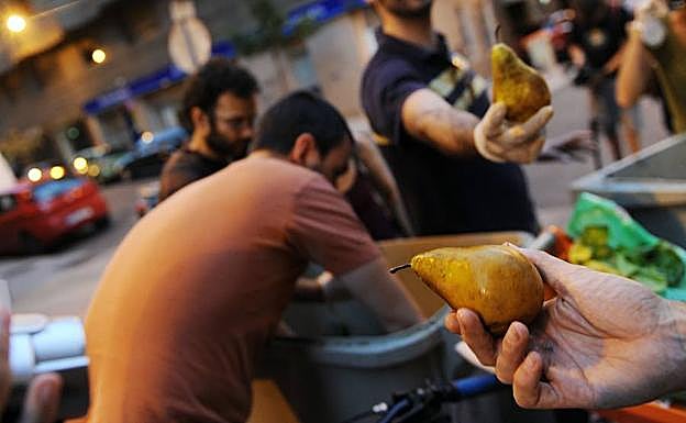 Un grupo de activistas recuperan en Madrid frutas en perfecto estado arrojadas al contenedor de la basura. 