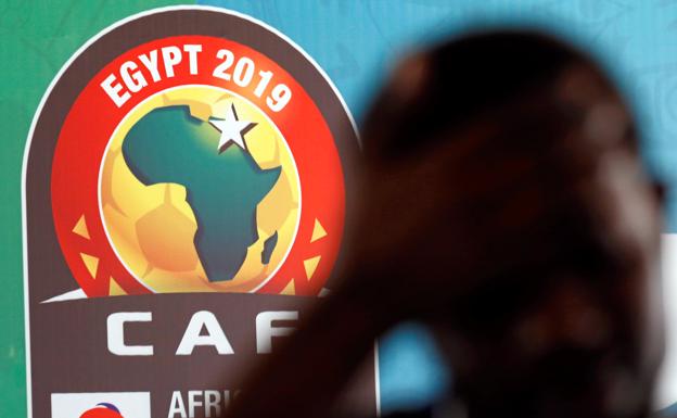 Un ciudadano africano camina cerca de un cartel de la Copa de Äfrica que se celebra la próxima semana en El Cairo.