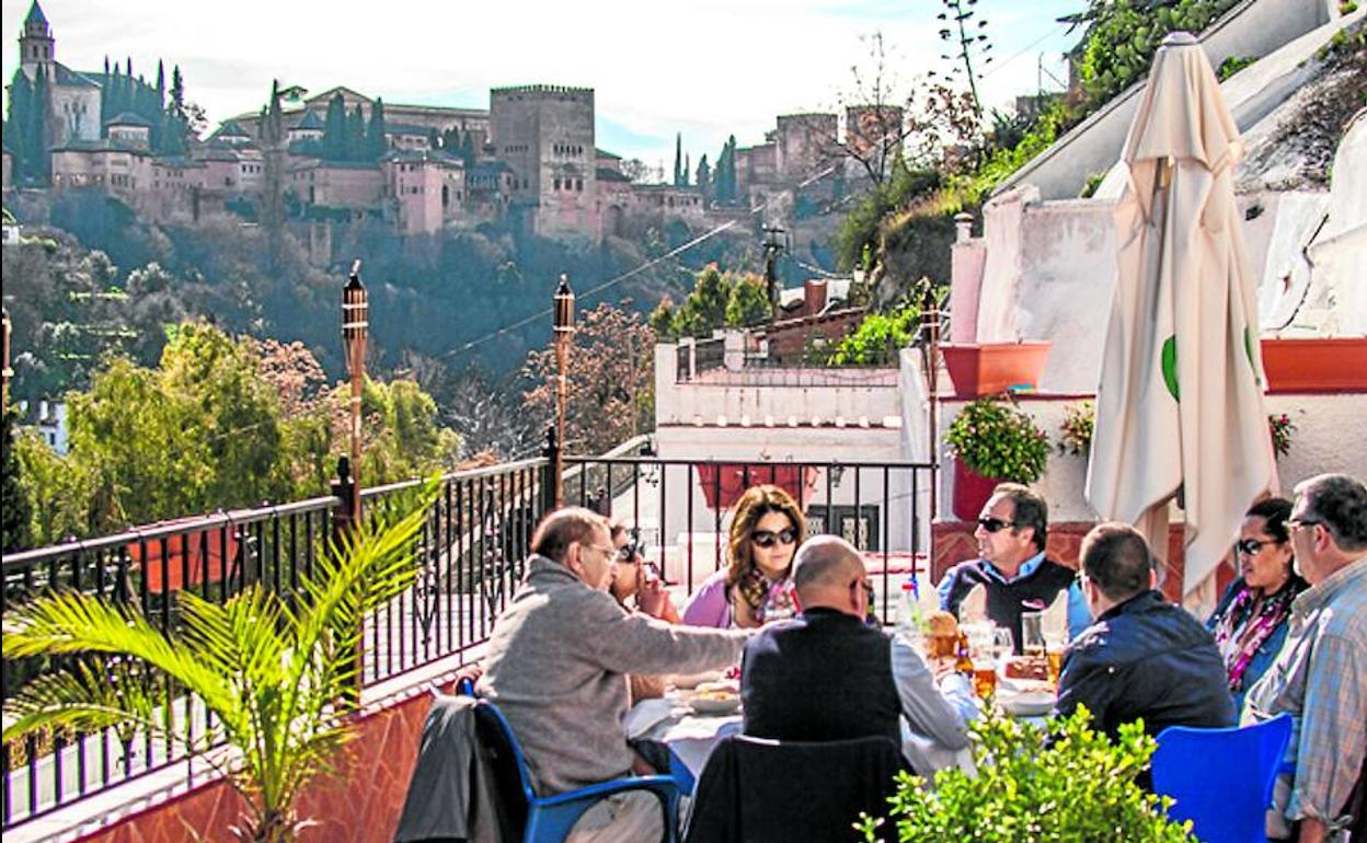 Turistas en un carmen del Albaicín, con la Alhambra de fondo.