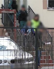 Imagen secundaria 2 - Arriba, una de las implicadas habla con una de las víctimas. Abajo, entrada en el domicilio del municipio de El Espinar y registro de la Guardia Civil.