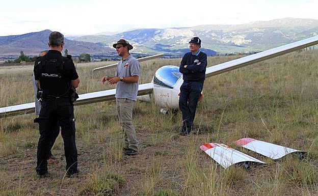 André charla con un policía nacional mientras Arnaud espera junto al planeador. 
