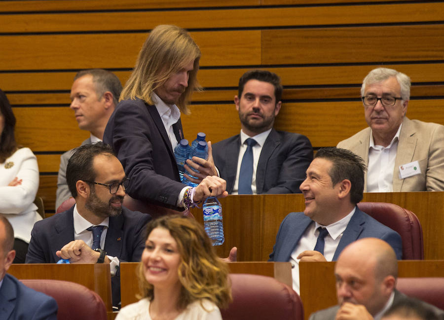 Imagen secundaria 1 - El procurador socialista José Francisco Martín exhibie una carpetilla del PSOE. Debajo, Pablo Fernández (Podemos) reparte agua a Vox y UPL, y Fernando Rey lee unos apunts. 