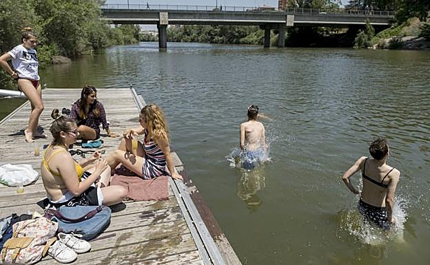 Un grupo de jóvenes combate la ola de calor con un baño en el río Pisuerga.