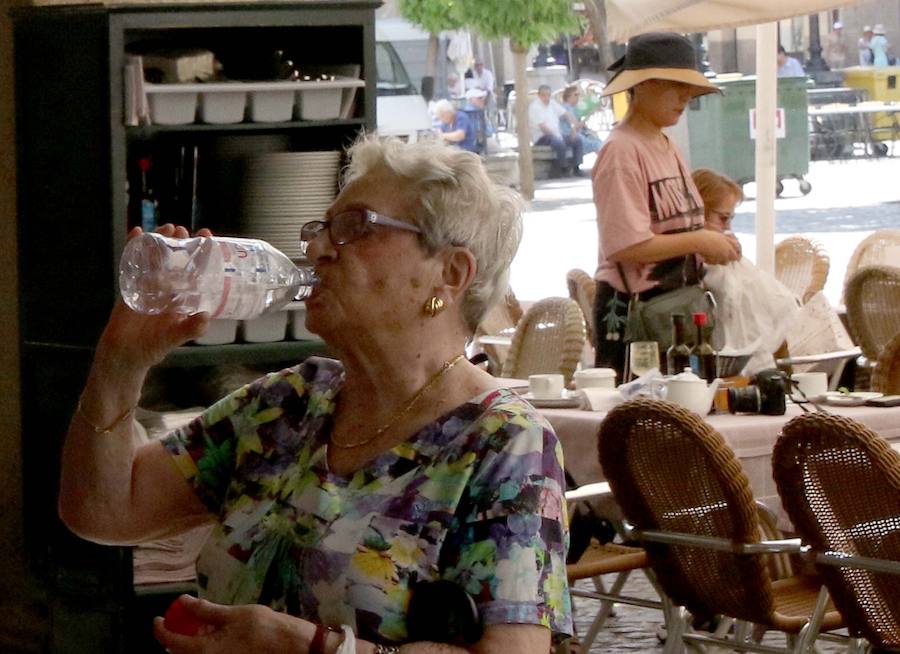 Una mujer se refresca con una botella de agua.
