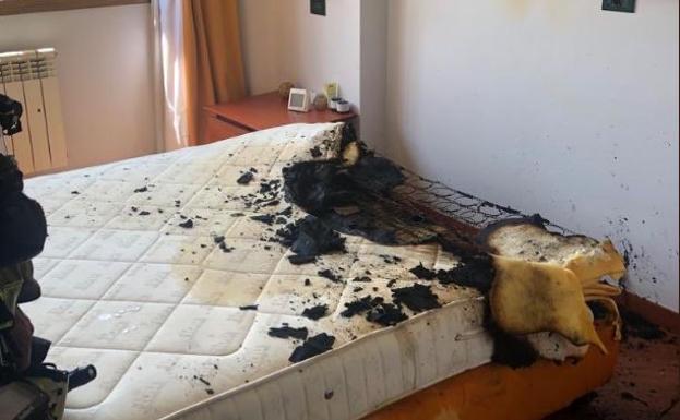 Un cargador de móvil sobre una cama provoca un incendio y calcina uno de los colchones de la vivienda.