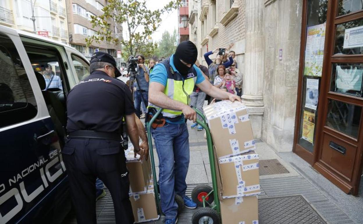 Un agente de la Udef carga con una carretilla documentación de adjudicaciones en el Ayuntamiento de Palencia, en julio del año pasado. 