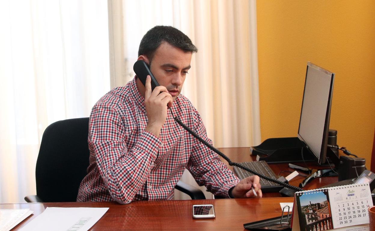 Carlos Fraile habla por teléfono en su despacho. 