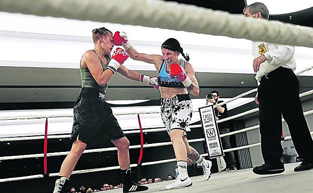 Imagen principal - Arriba, 'La Reina' cruza guantes con la boxeadora Bianka Nagy durante un combate en barcelona. En medio, la boxeadora besa a Joaquín, su marido, mientras se toca la cabeza. Aún le duele la zona de un golpe recibido en el último combate. Abajo, Joaquín, de seis años, bromea con el tamaño de los bíceps de su madre mientras pasean al perro.