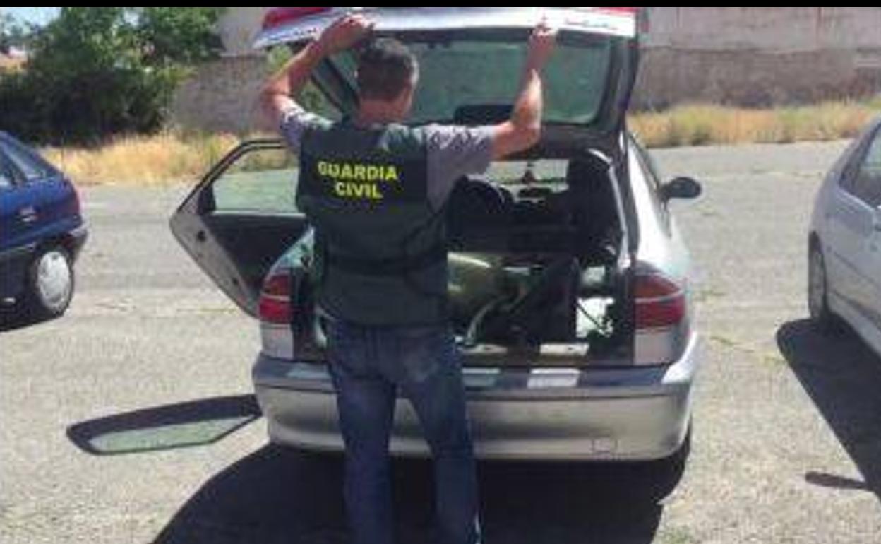 Un agente inspecciona el vehículo de los detenidos.