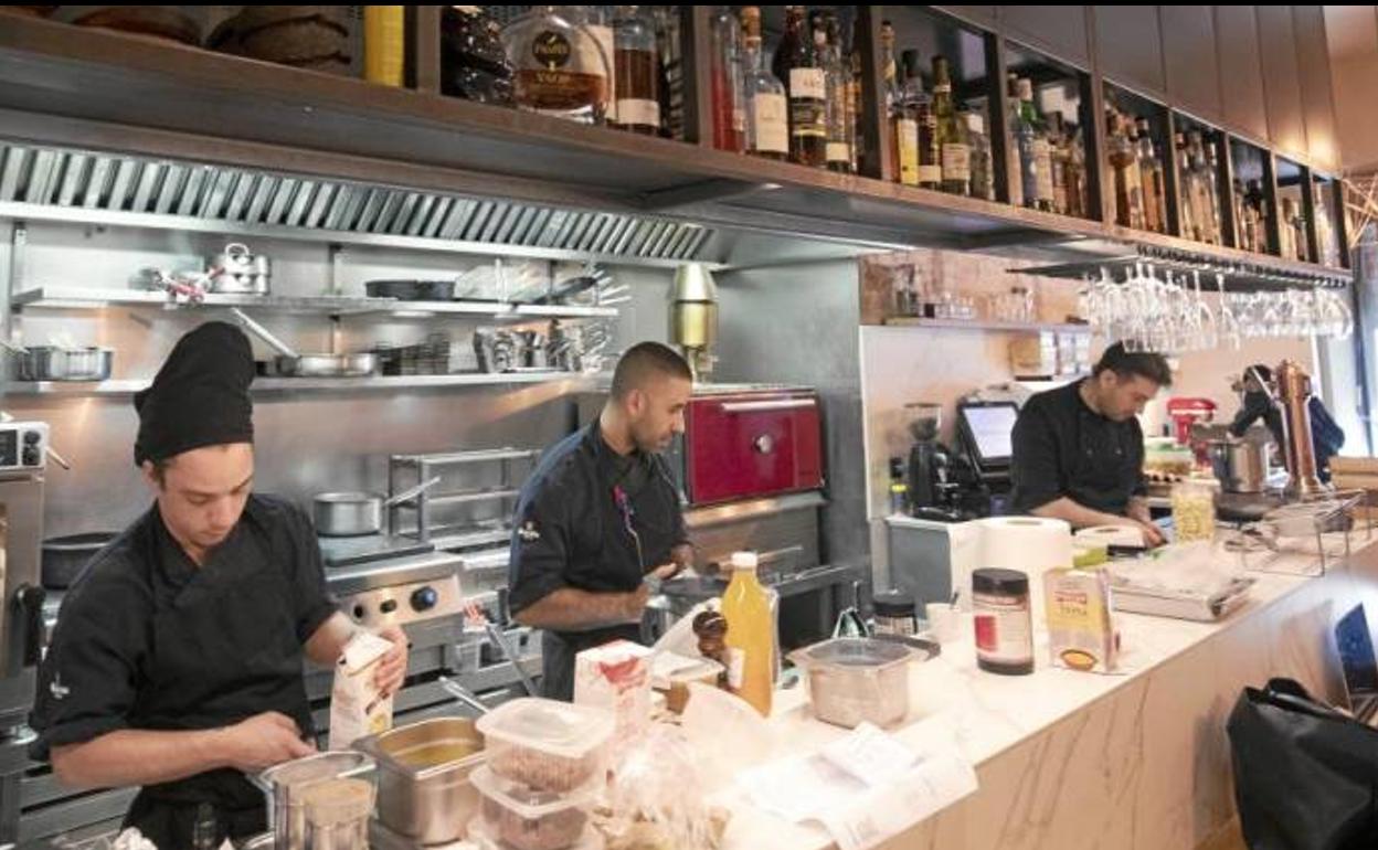 Cocineros y camareros trabajando en un restaurante.