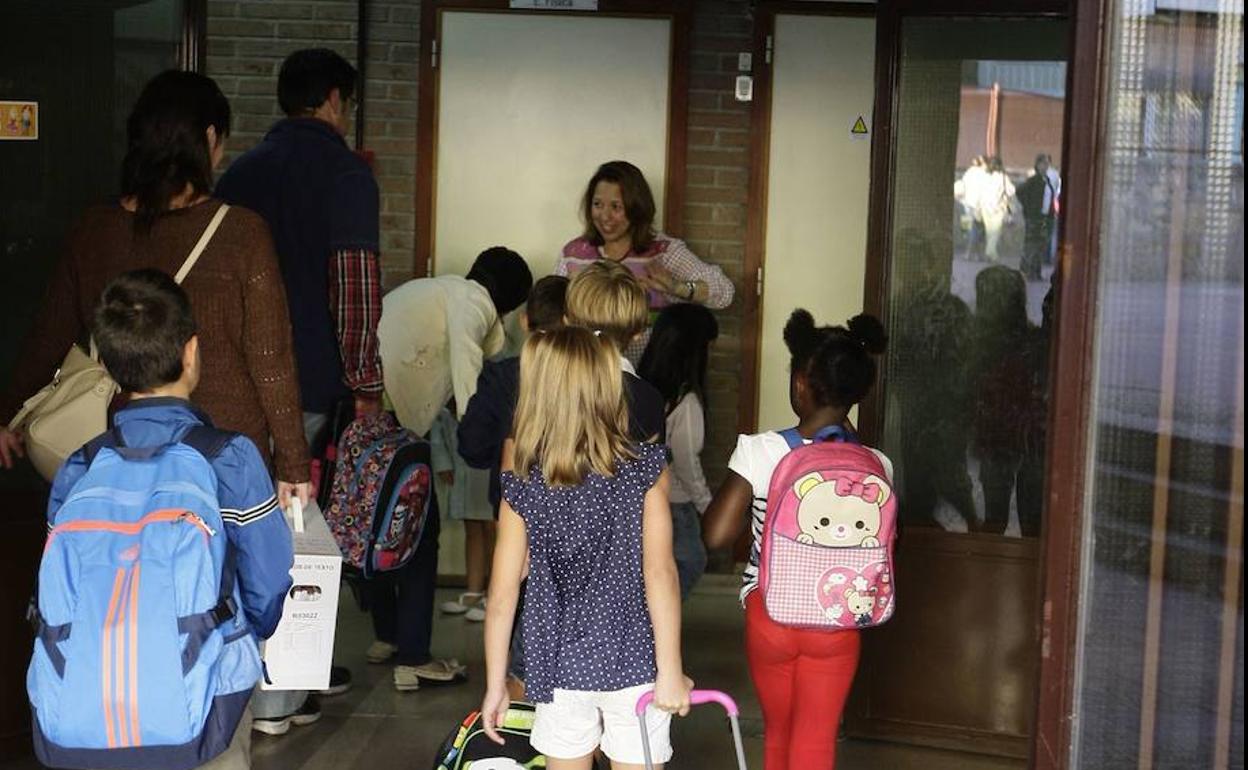 Varios alumnos acceden con las mochilas a su colegio para asistir a las clases. 