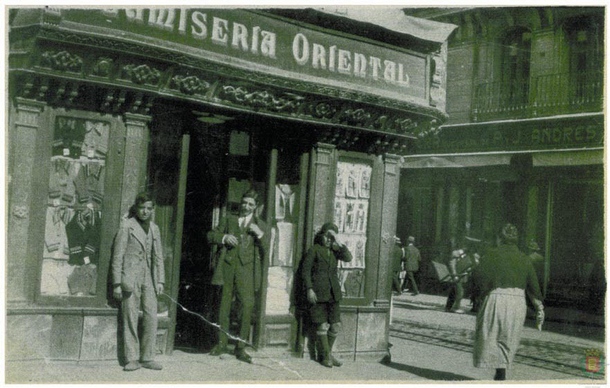 El propietario y los empleados de la Camisería Oriental, a la entrada de la tienda, en el decenio de 1930, en la calle Santiago.