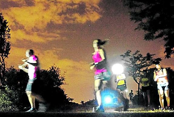 Imagen principal - Magia nocturna . Participantes en la 'full moon running' celebrado el martes en la Casa de Campo de Madrid. 