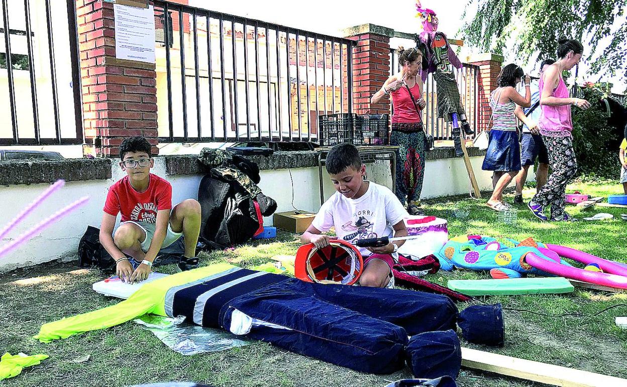 Varios niños del taller y adultos confeccionan los espantapájaros con ropas cedidas por los vecinos.