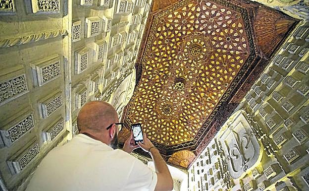 Un visitante fotografía un artesonado en el acceso de las escaleras al claustro.