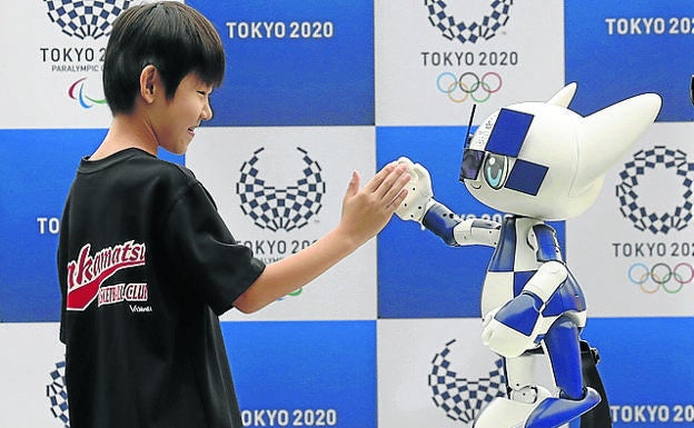 Imagen principal - Miraitowa, la mascota robotizada, saluda a un niño; un grupo de fotógrafos, en el interior del estadio olímpico y ensayos con autobuses autónomos en el aeropuerto.