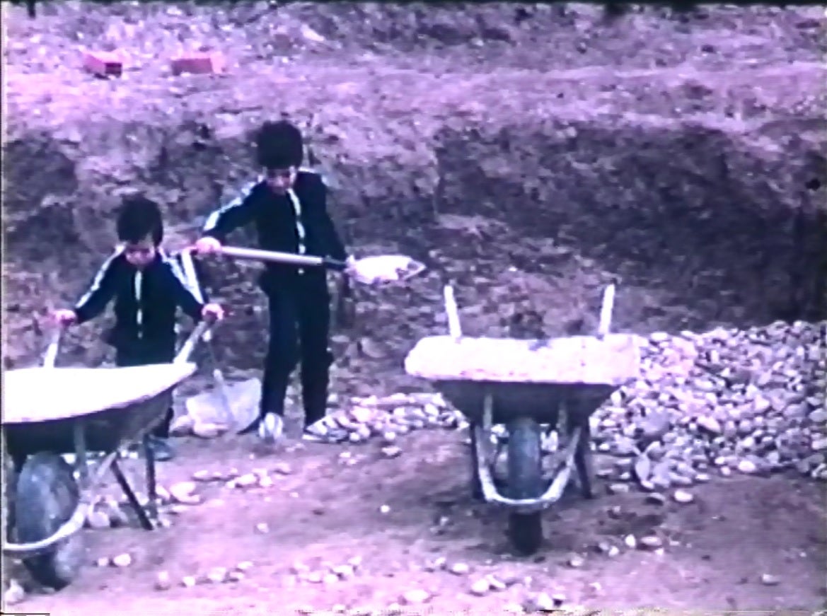 Fotograma del vídeo 'super 8' en el que mi hermano Roberto, a la izquierda, y yo, tratamos de acarrear piedras para construir la piscina. 