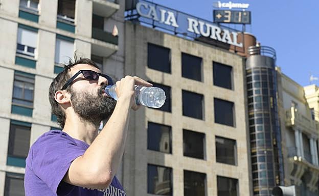 Un hombre se refresca en la plaza de Zorrilla. 