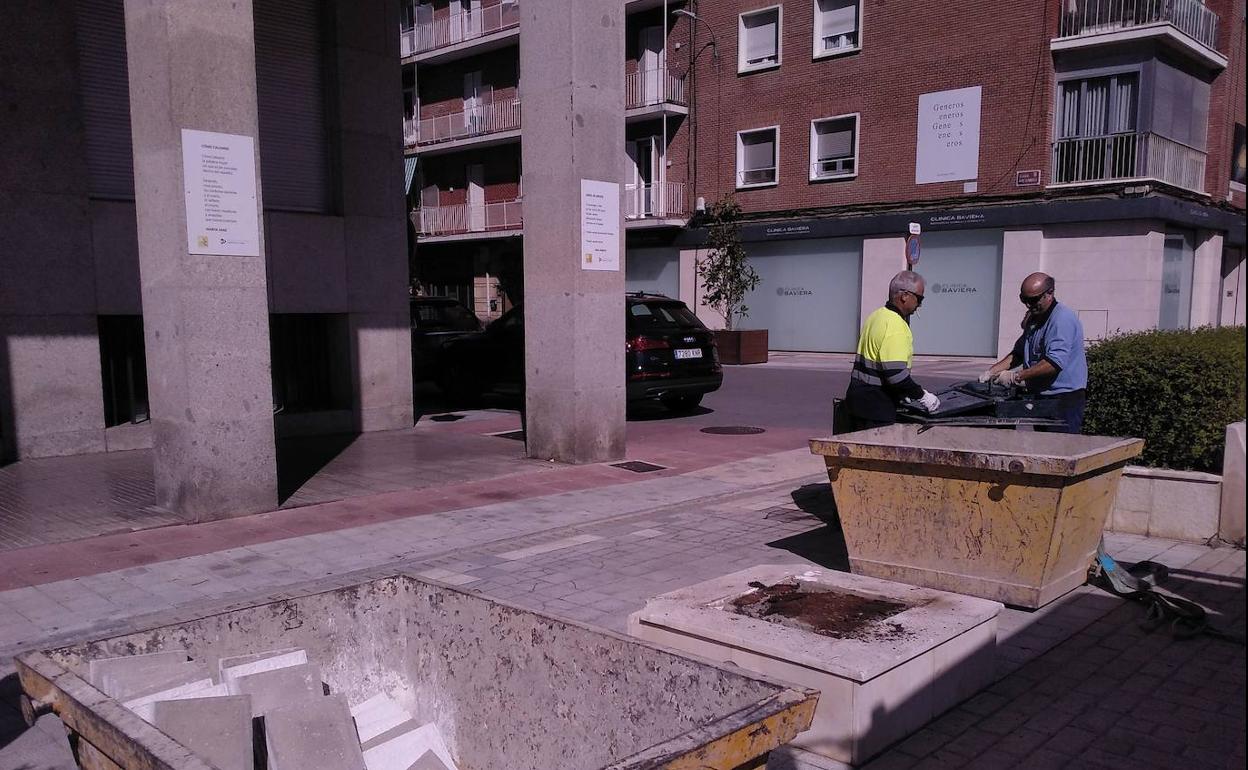 Dos operarios retiran el busto de Abilio Calderón en la plaza de los Juzgados. 