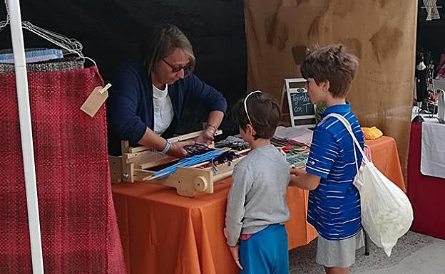 Niños aprendiendo cómo funciona un telar 