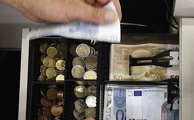 Caja registradora con dinero dentro. 