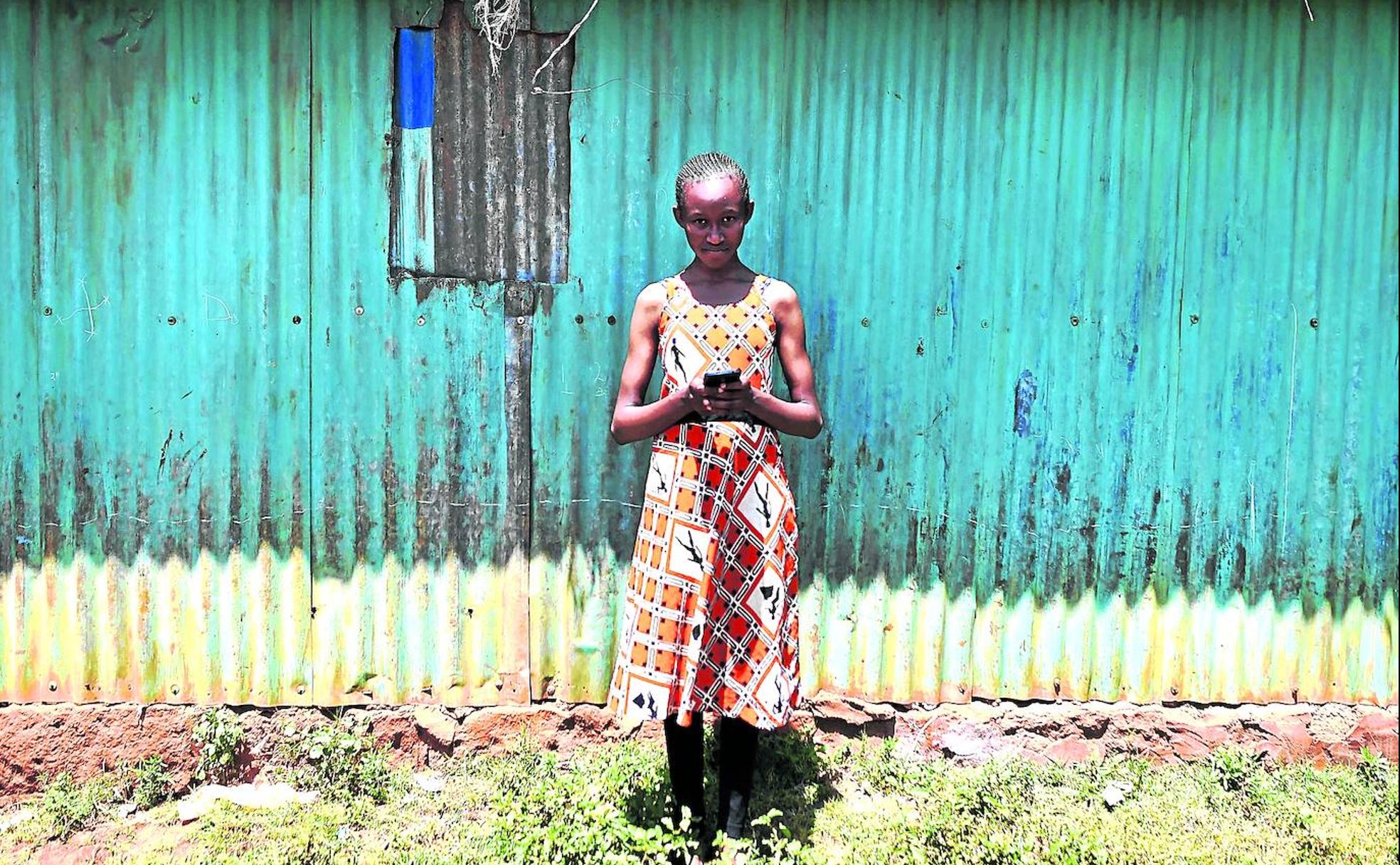La adolescente keniata Imelda Mumbi, de trece años, trata de captar cobertura para su móvil en las inmediaciones de su casa en Nairobi.
