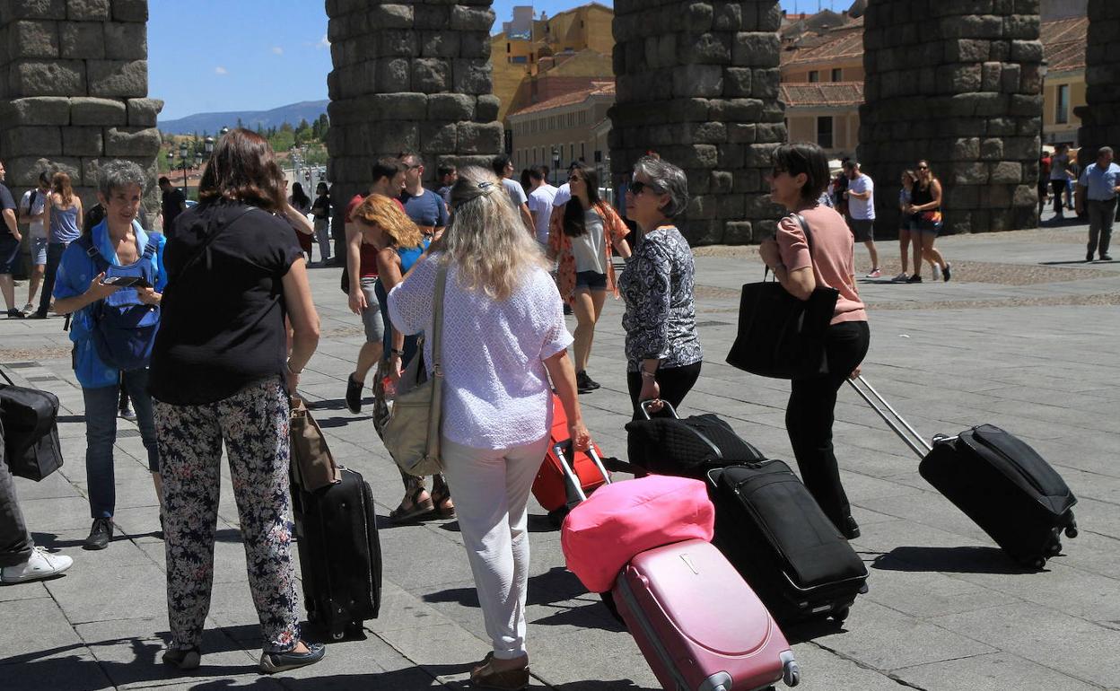 Turistas con maletas cerca del Acueducto. 