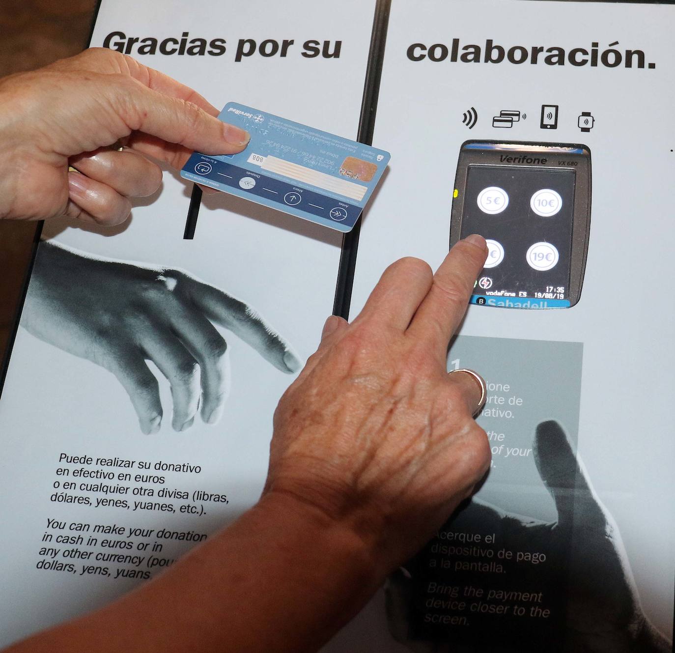 Una mujer marca el importe en el dispositivo de la catedral. :: 