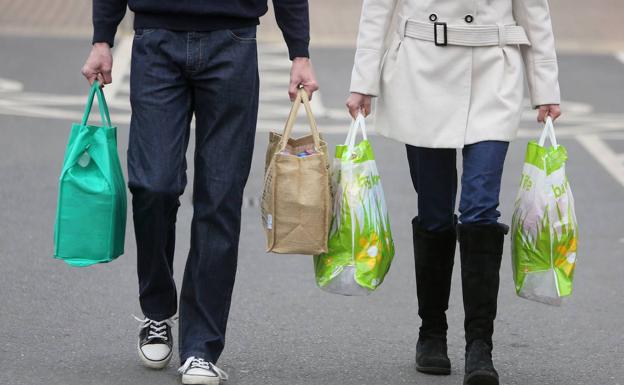 Una pareja, con las bolsas de la compra. 